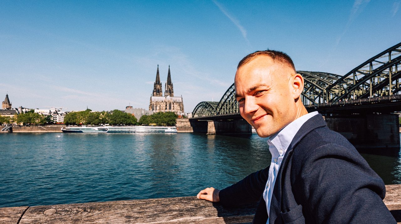 Leonard Kordowski in front of Cologne Cathedral and Hohenzollern Bridge
