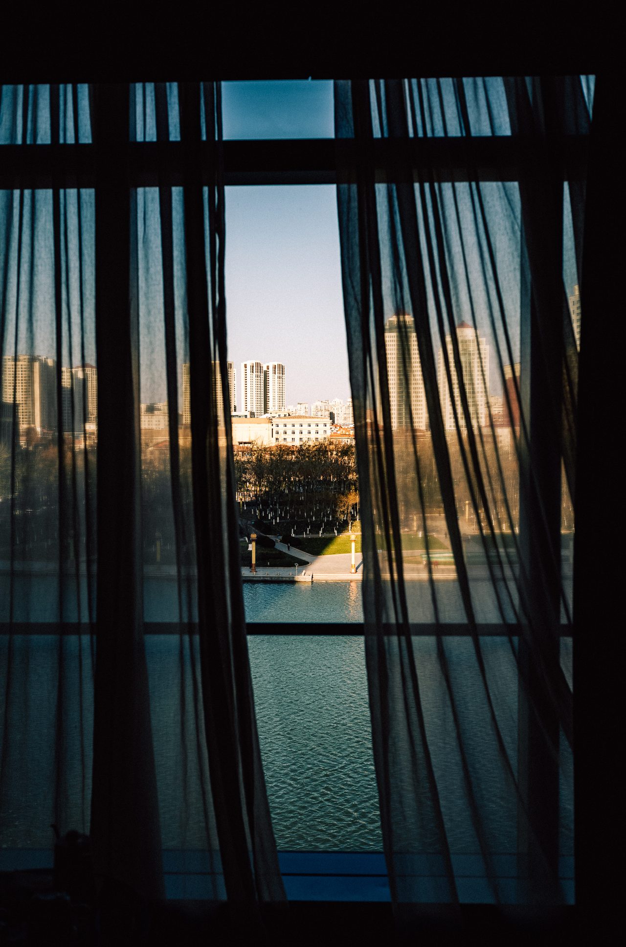 City view through open dark hotel curtains