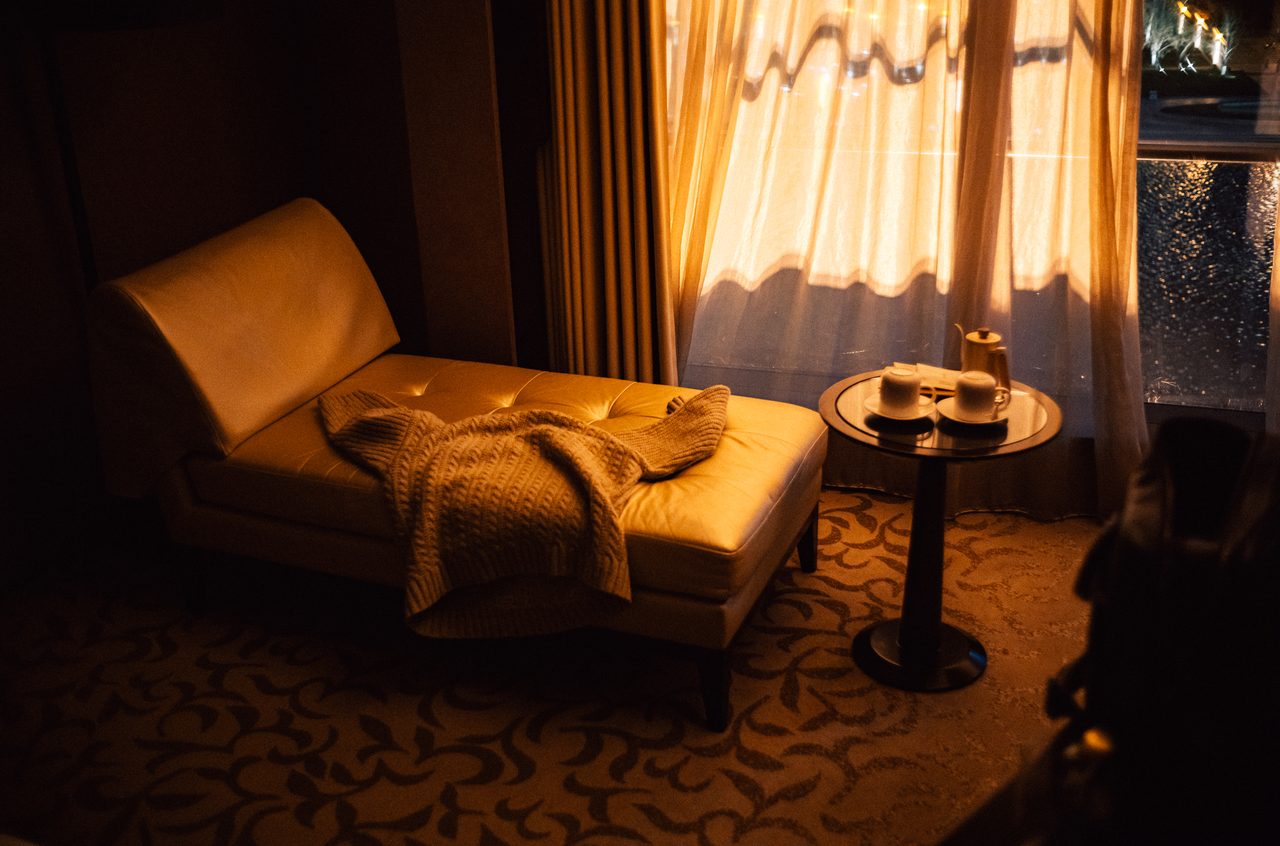 Chaise longue with a knitted sweater and tea service in evening light