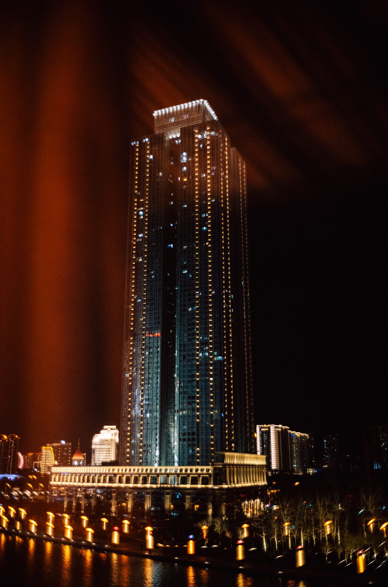 Illuminated skyscraper on a riverfront at night