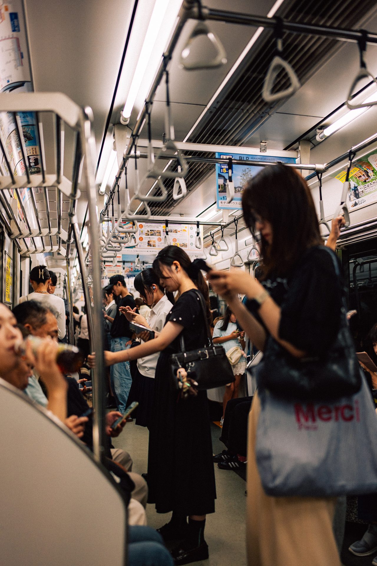 Passengers using smartphones in a crowded subway in Japan