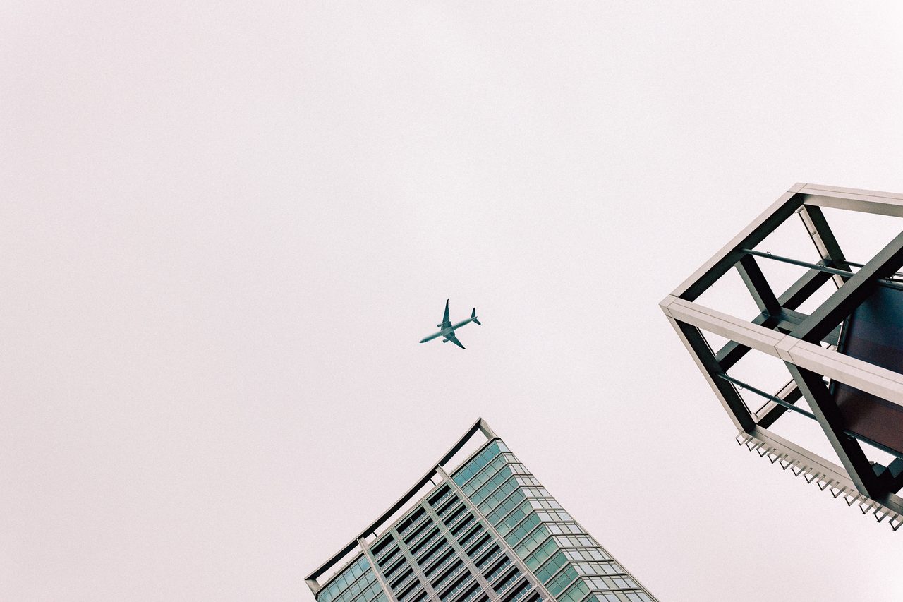 Passenger plane flying between two high-rise buildings
